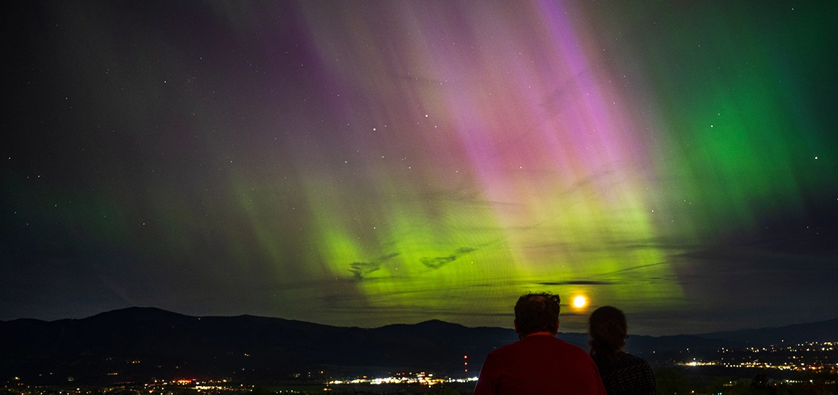 Two people observe the Northern Lights over Missoula