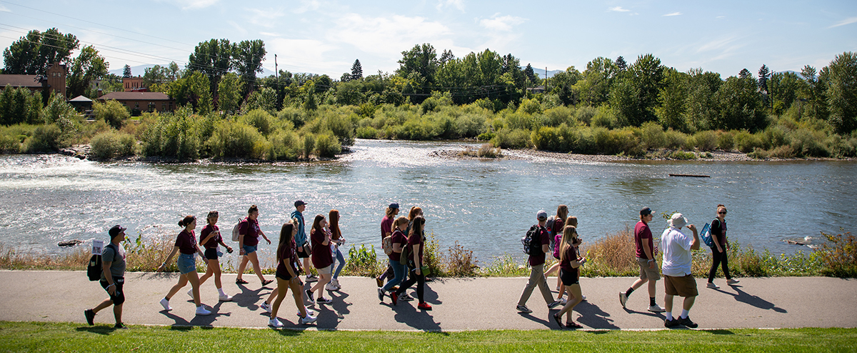 A group of UM students walk along the River Trail in Missoula