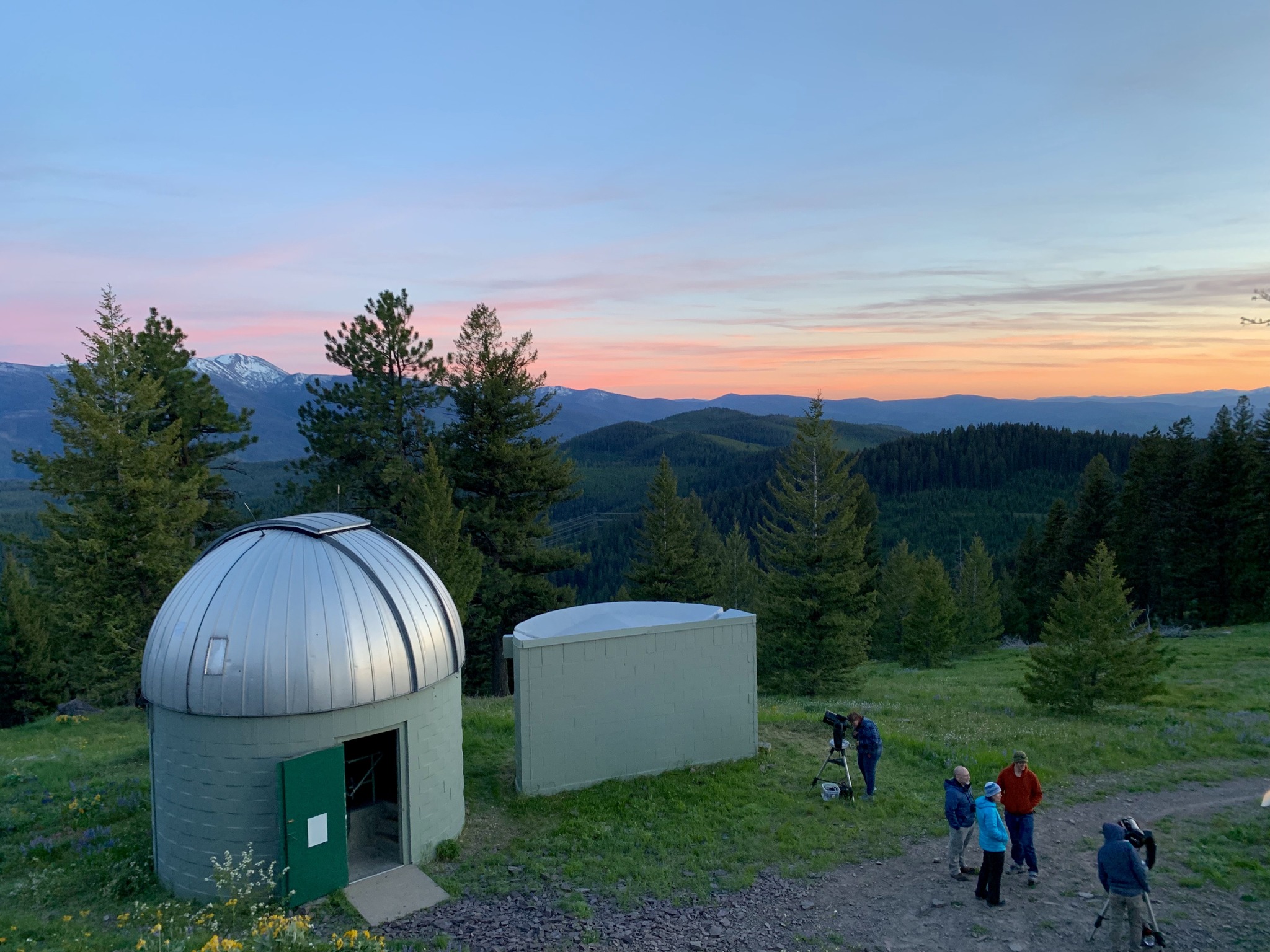 observatory dome at sunset with several people around