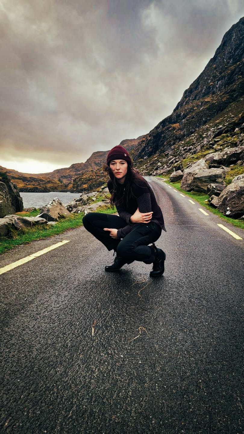 Piper posed on a road in the mountains near a lake in Ireland